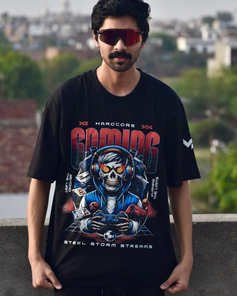 A stylish young man wearing a Swavable black oversized graphic T-shirt with a bold futuristic print, posing confidently outdoors in natural light.